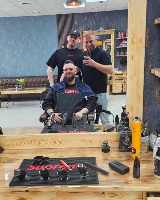 Kunde und Barbier nach dem Schnitt, beide lachen in die Kamera